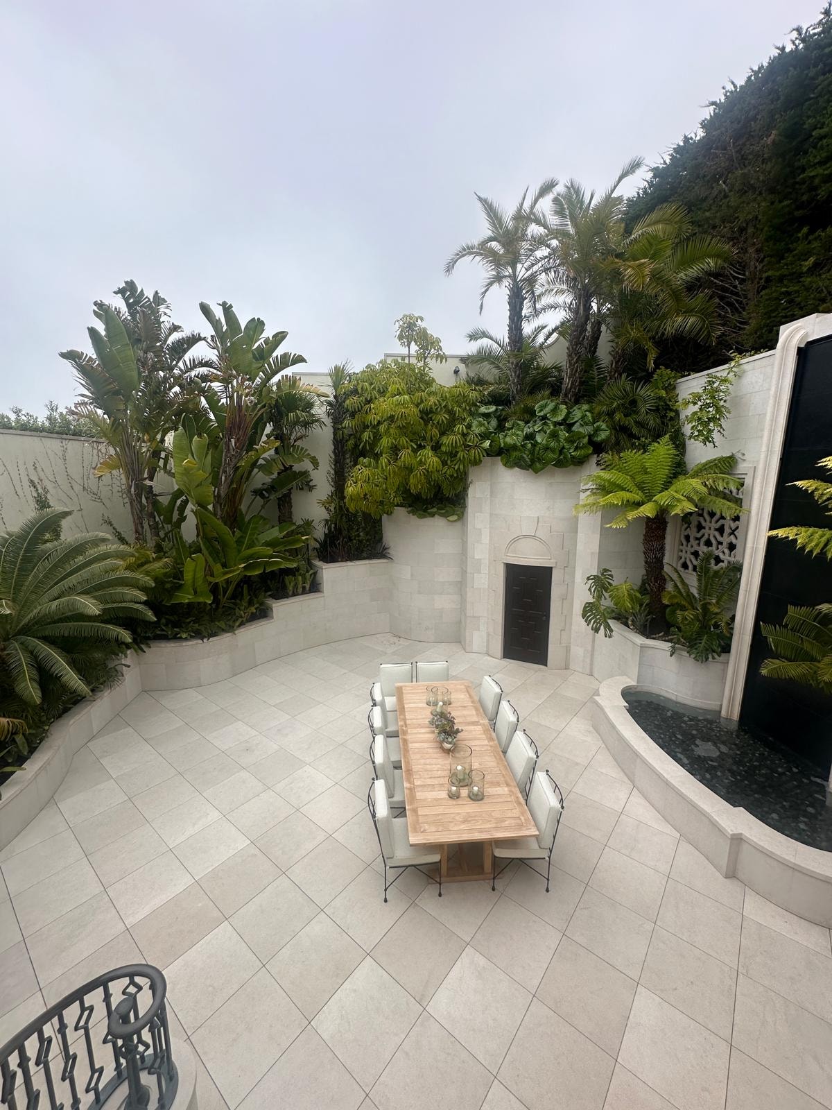 Stone-clad courtyard with tropical landscaping and dining terrace