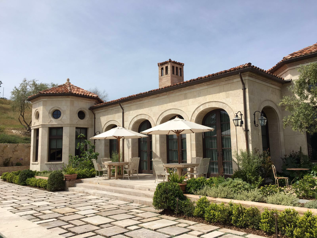 Stone patio with arched facade and terracotta roof