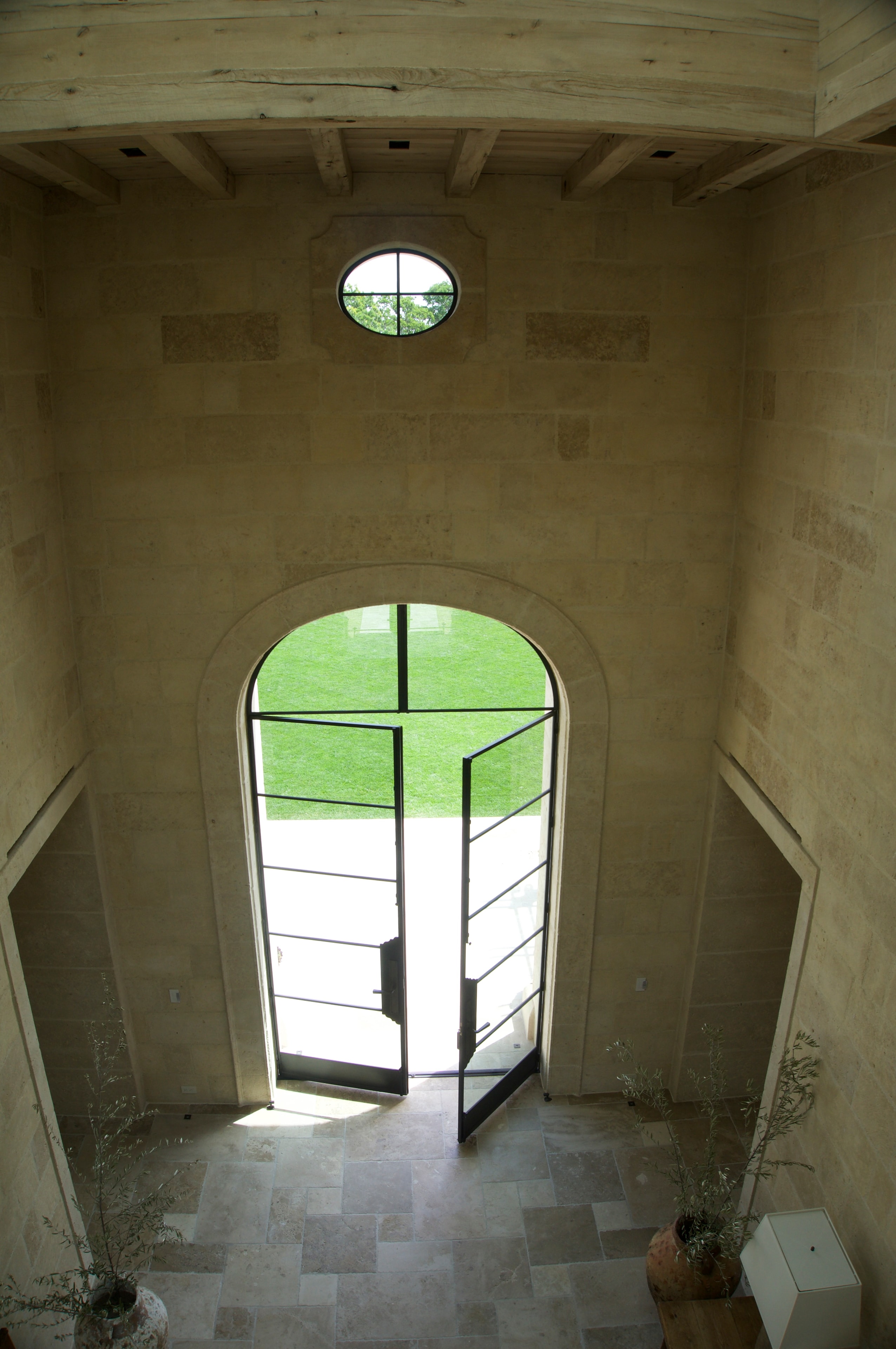 Interior arched entry with stone surround and oval clerestory window